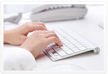 Hände auf einer Tastatur am Arbeitsplatz